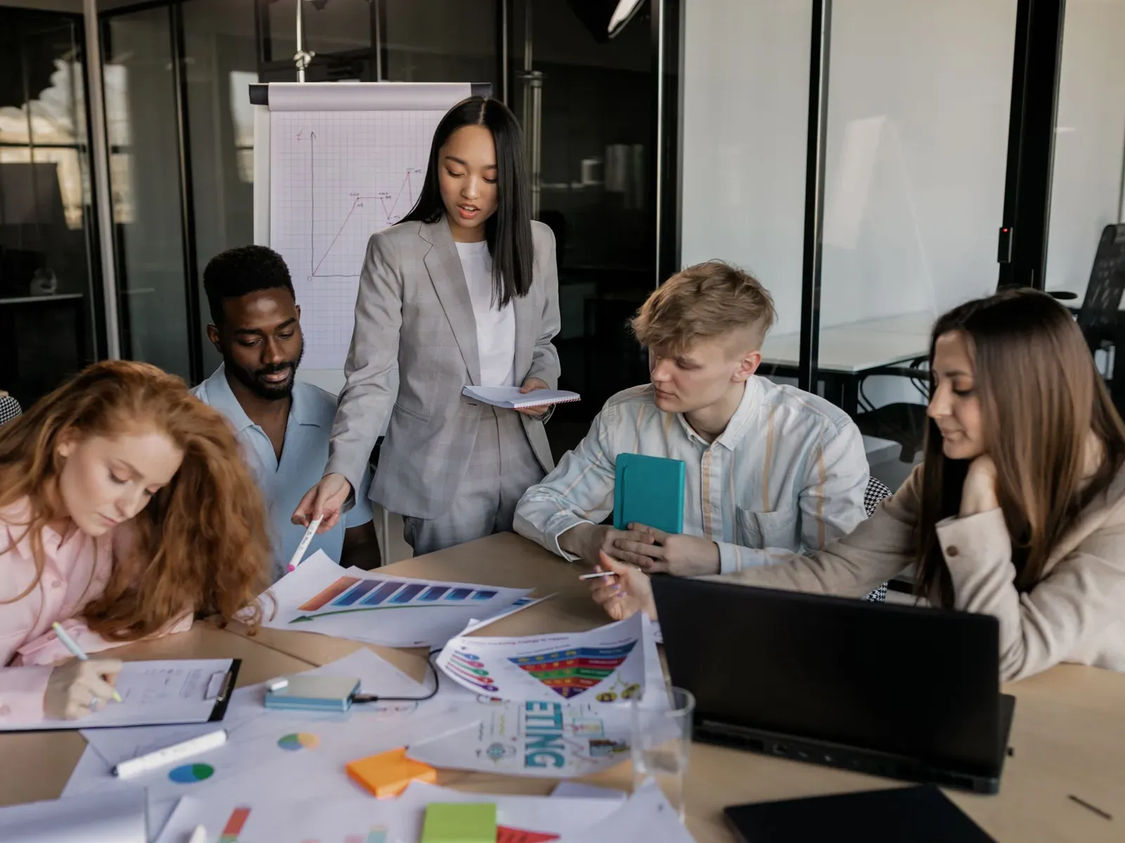 A small team working together around a table in a bright office