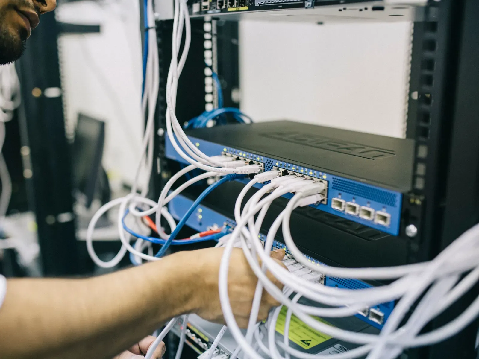 An engineer configuring network cabling in a server rack