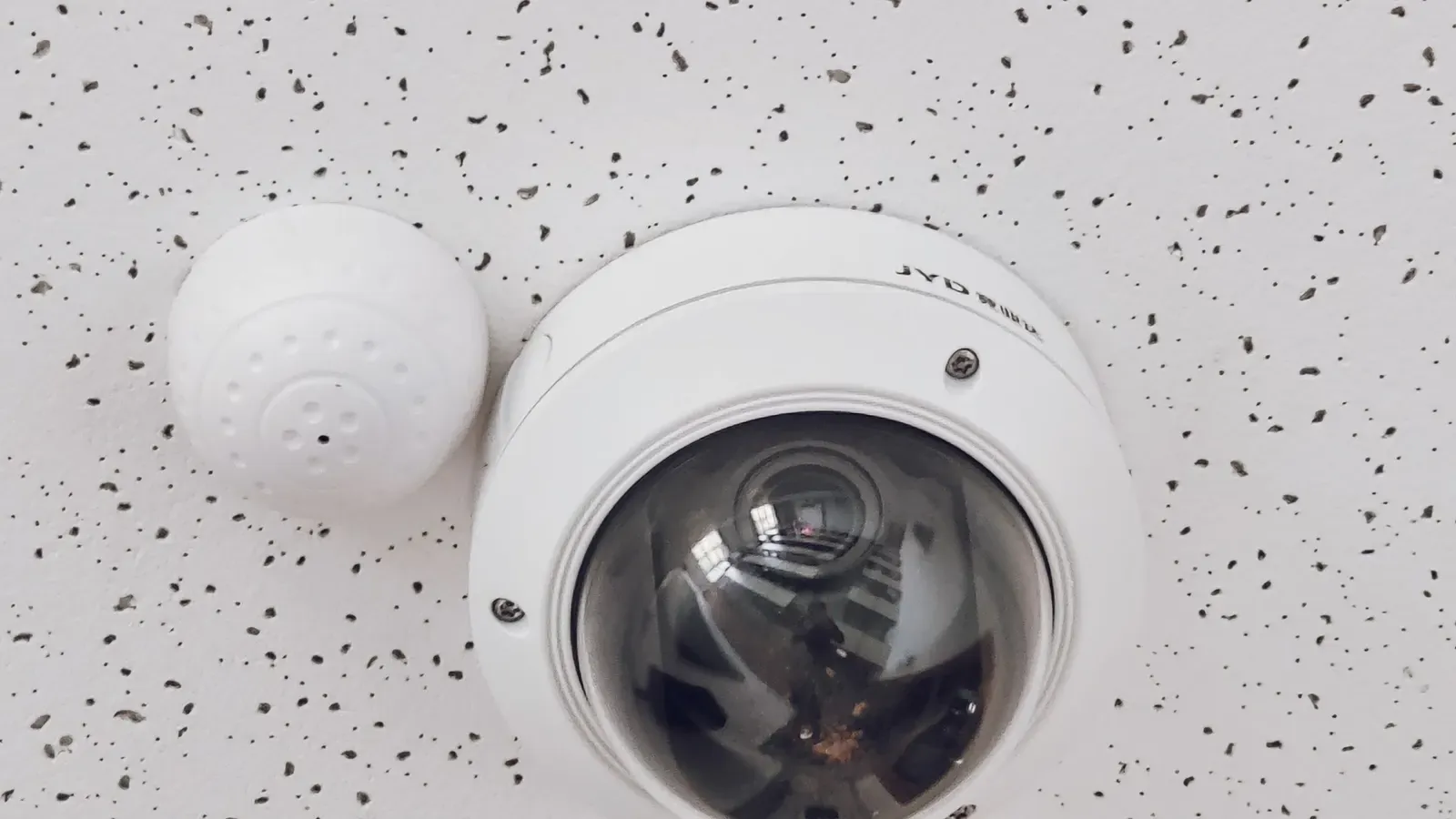 A dome security camera installed on an office ceiling